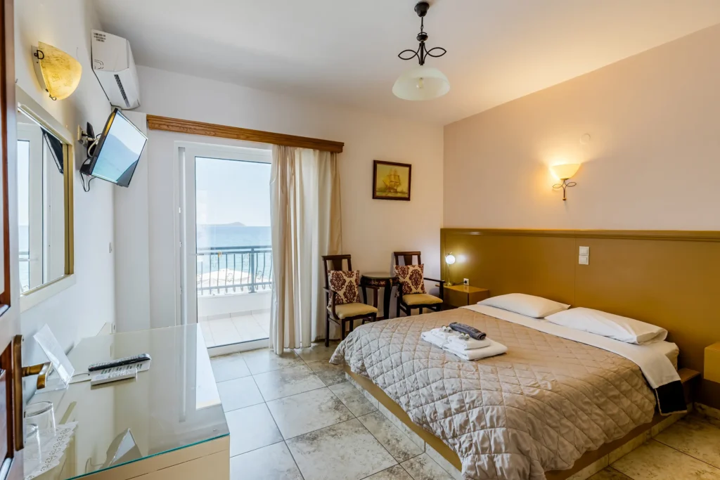 Hotel Filoxenia bedroom with a double bed, sea view balcony, and vanity desk