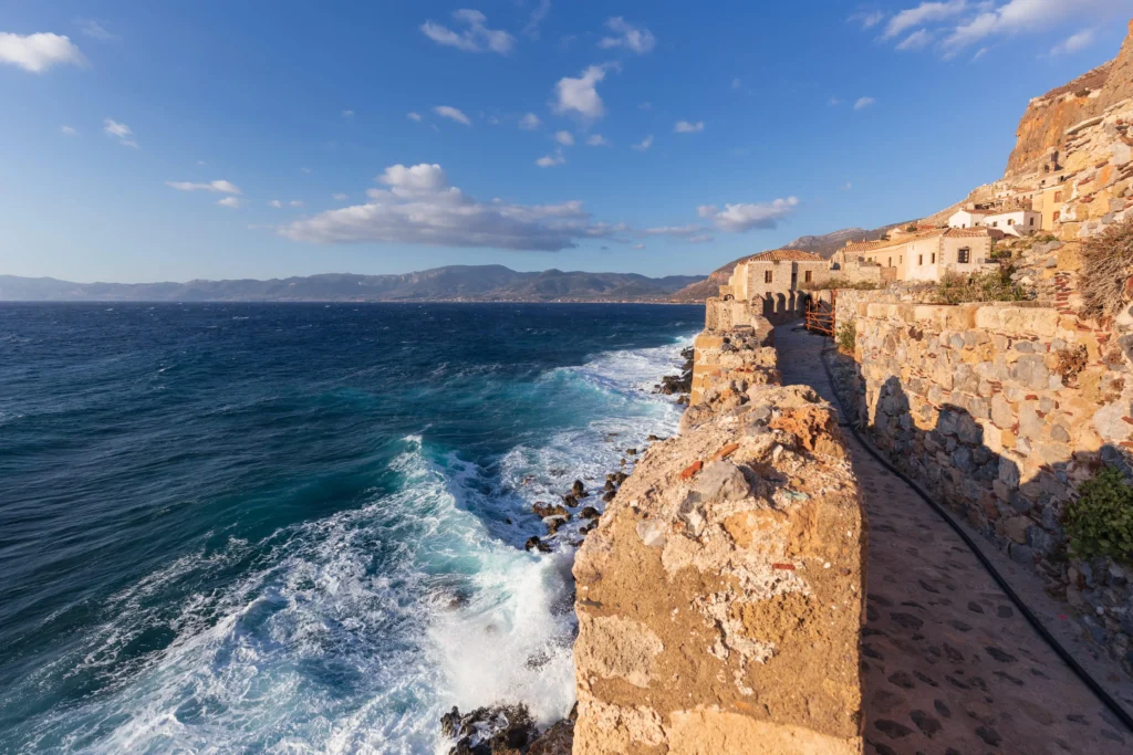 view of the sea-facing stone fortress walls and pathway of ancient Monemvasia in Greece